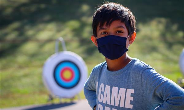 Boy stands in front of target